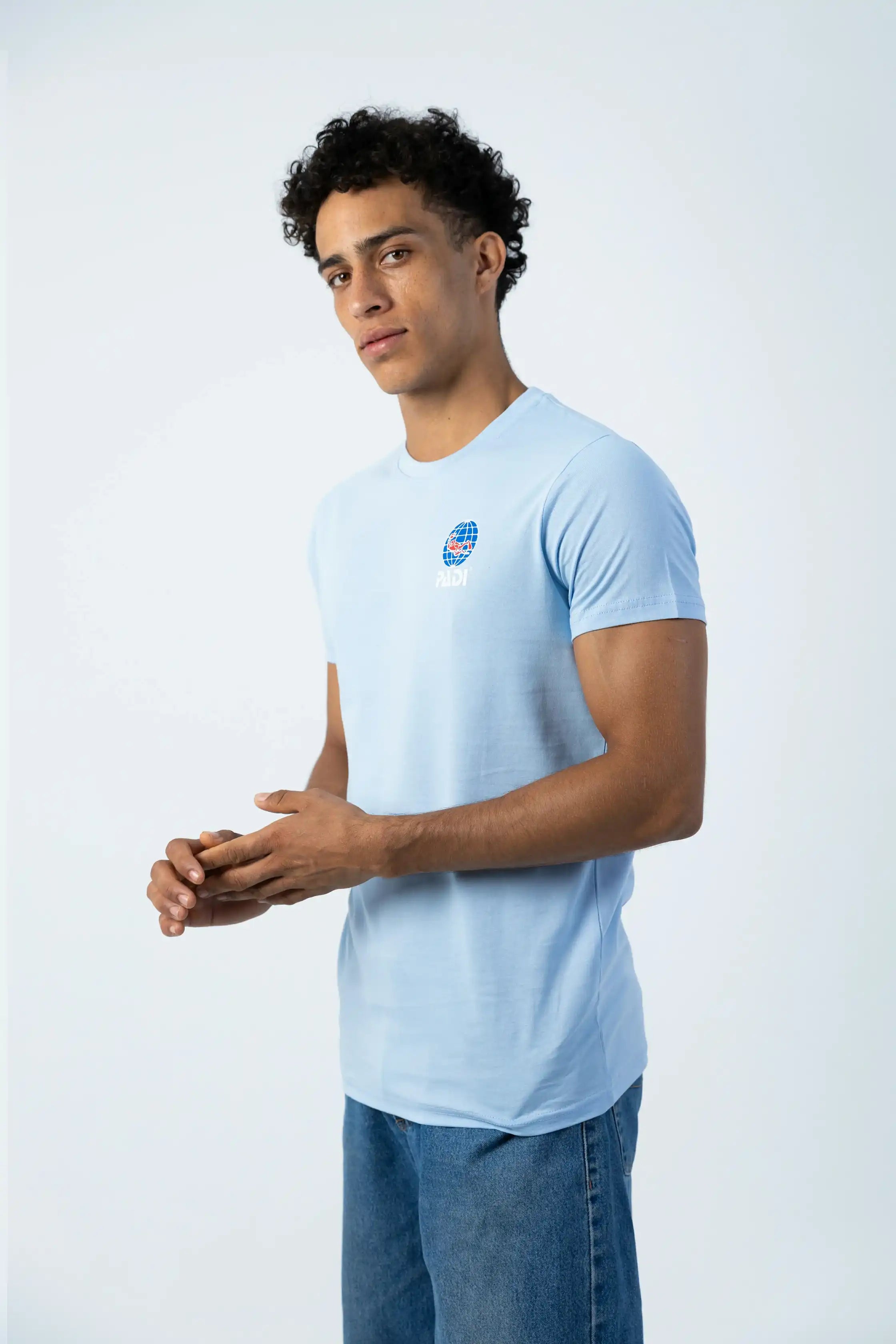 Man wearing a light blue t-shirt with a logo on a white background